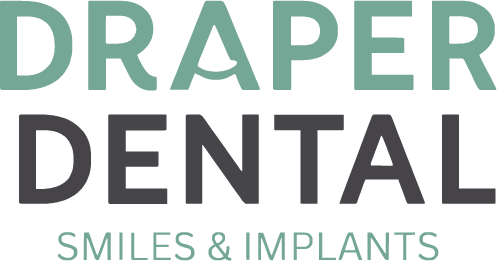The image features a logo with text that reads  Draper Dental Smiles   Implants  in white font against a dark background. The style of the image is graphic, with a modern and clean design.