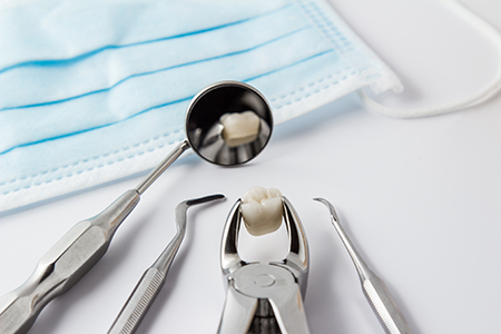 The image shows a dental office setting with various dental tools and equipment, including a toothbrush, dental floss, and dental instruments, all neatly arranged on a table with a blue cloth underneath.